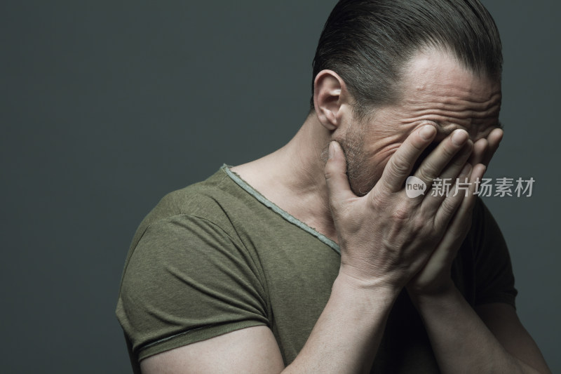 男性双手捂脸神情沮丧