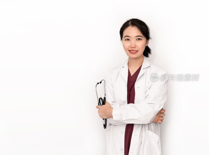 站在白色背景前拿听诊器的中国女性医生
