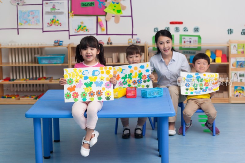 幼儿园女老师和儿童展示手工儿童画