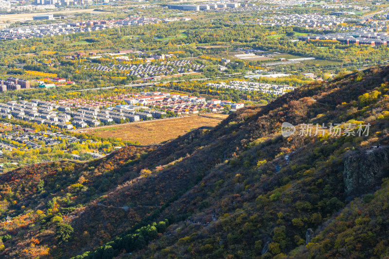 俯瞰多彩山林及山下城镇的秋景