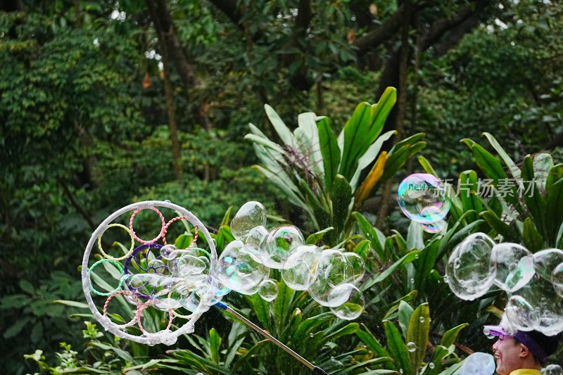 户外绿植旁吹泡泡场景