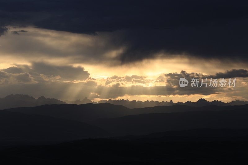 山峰日落时天空映衬的剪影景观