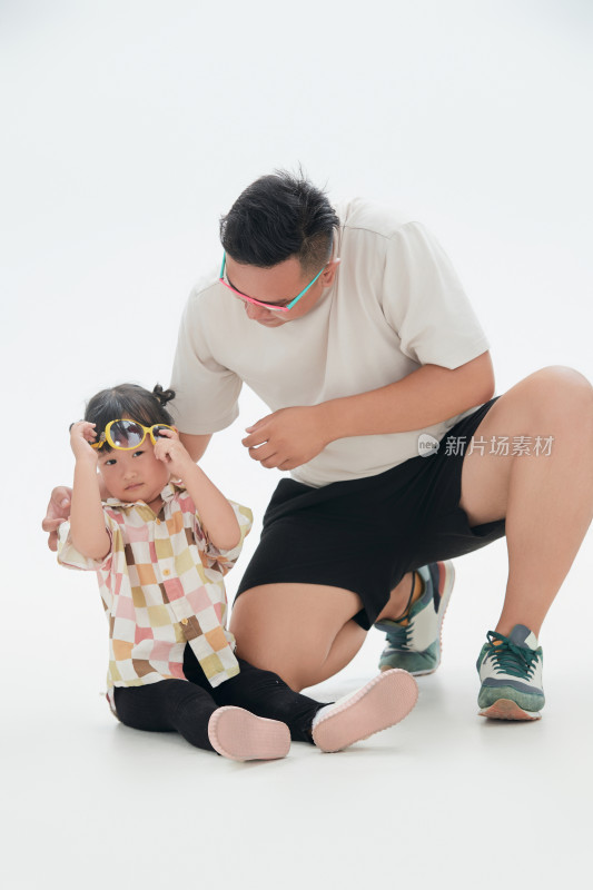 白色背景下的爸爸与可爱女儿玩耍（亲子人像）