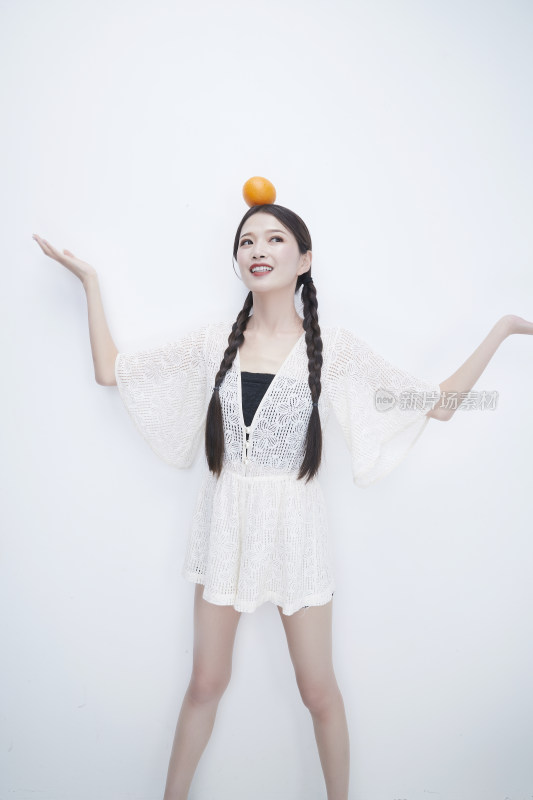 头顶橙子身穿镂空连衣裙的亚洲可爱少女人像