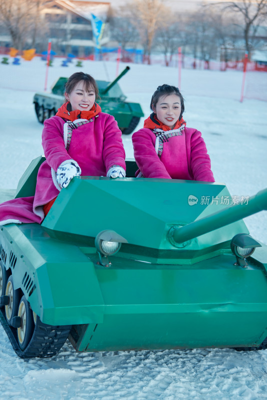 在冰天雪地玩耍雪上娱乐载具车辆的闺蜜少女