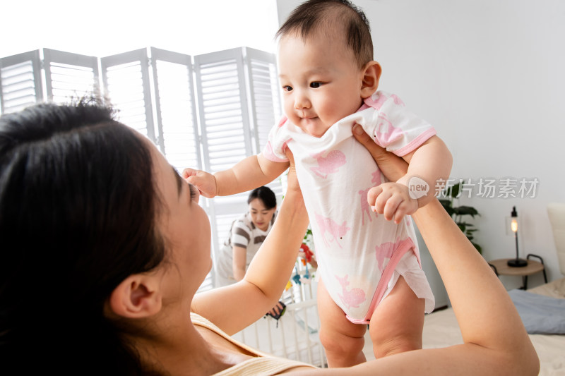 年轻妈妈抱着宝宝玩耍