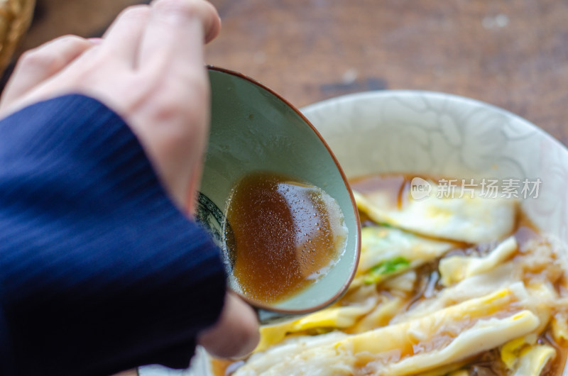 美味的广东特色小吃肠粉中倒入酱料