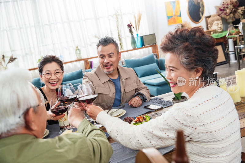 室内聚会上干杯庆祝的两对中老年夫妇