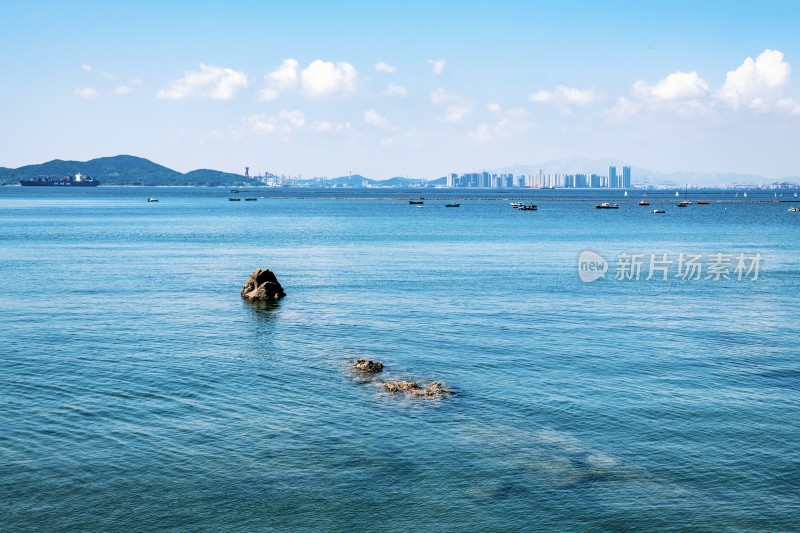 海面礁石与远处城市景观