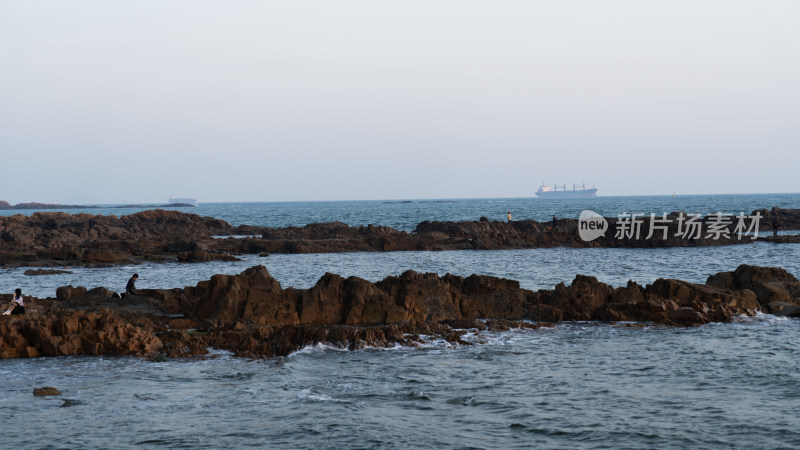 海边礁石上有人的海景画面