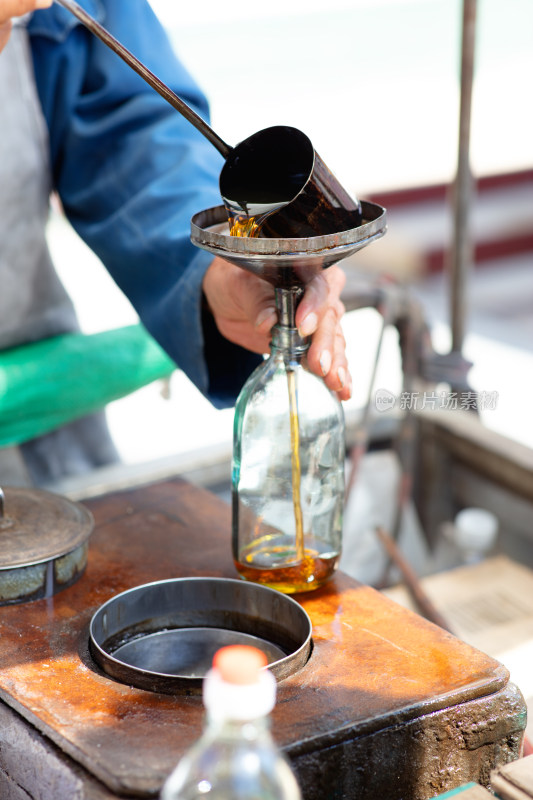 卖香油的小商贩灌香油特写