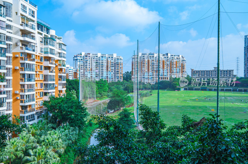 高尔夫球场绿色草坪与城市住宅高楼建筑