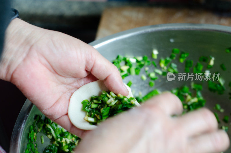 正在包韭菜鸡蛋饺子的女人的手特写