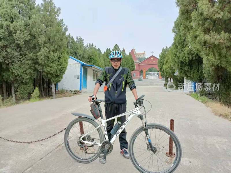 戴头盔男子手持山地车站在户外