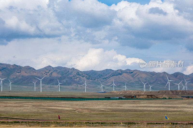 新疆草原雪山下的新能源风力发电机