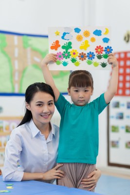 幼儿园女老师和儿童展示手工儿童画