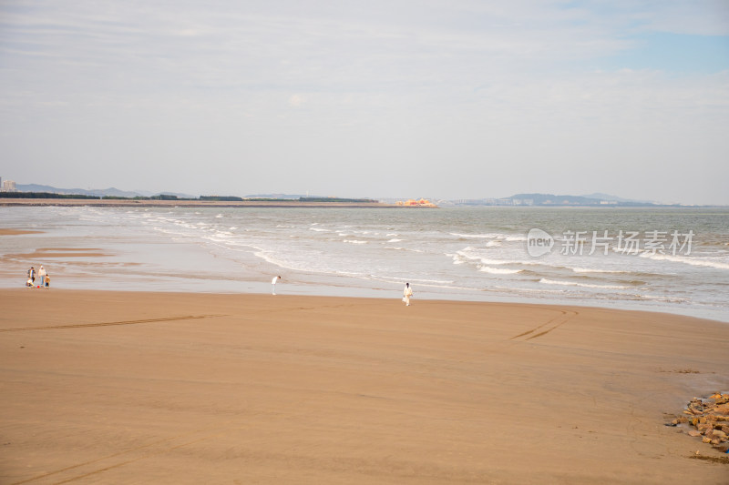 沙滩上人们漫步海边场景