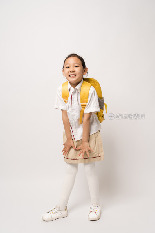 站在白色背景前穿校服的中国女孩