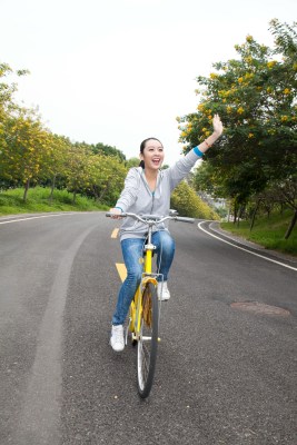 一个年轻女大学生在校园里骑车