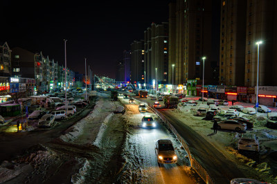 夜晚积雪街道车来车往的城市景象