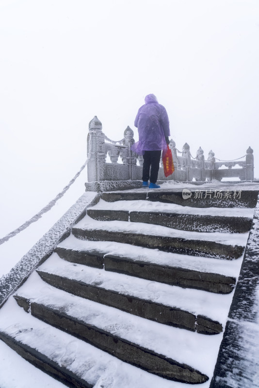 寒冷冬天大雪中攀登台阶的游客