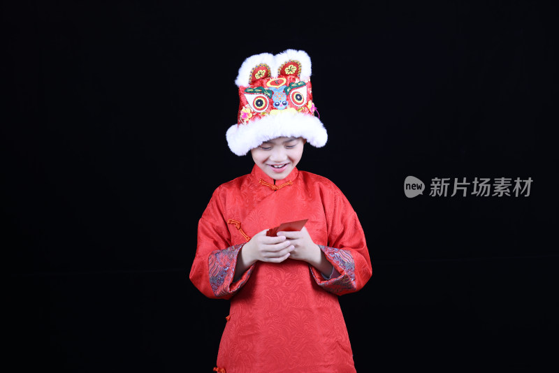 带虎头帽的中国小男孩和新年红包