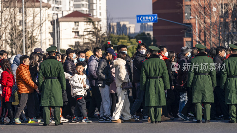 街头人群聚集有安保人员维持秩序