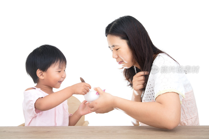 白背景前年轻妈妈端着碗正为女儿喂饭