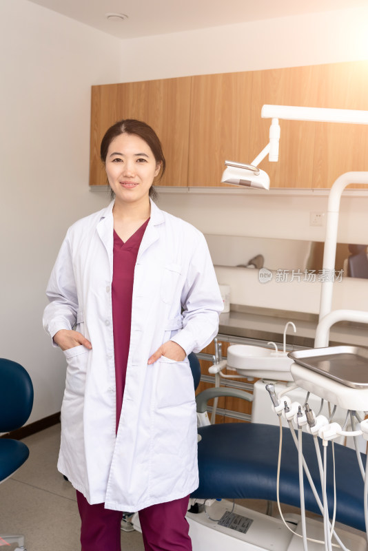站在牙科治疗室的中国女性牙医