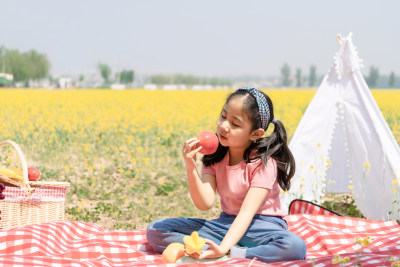 夏天在油菜花田野餐的女孩