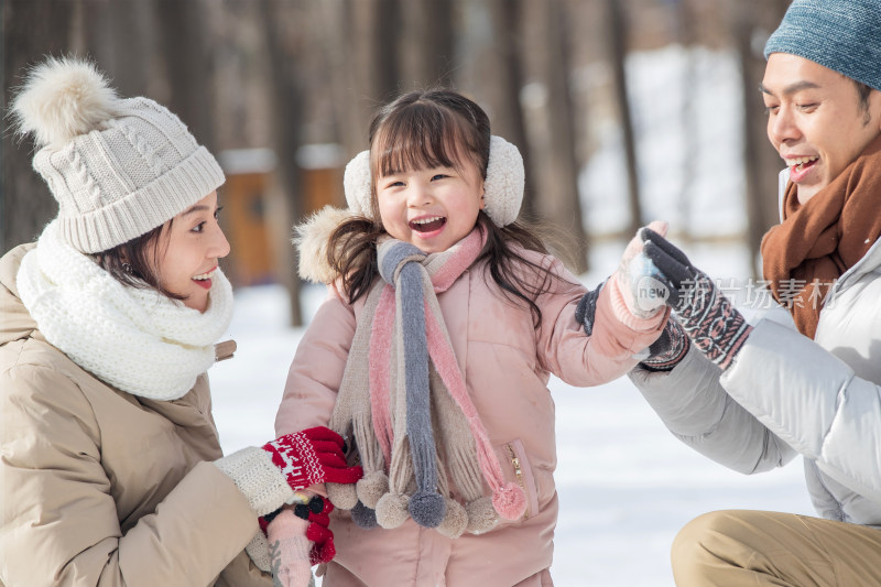 一家三口在雪地里玩耍