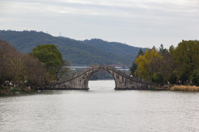 湘湖卧虹桥横跨水面，周围绿树环绕的美景