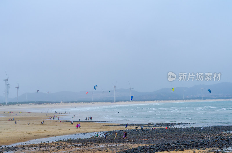 海边沙滩上风帆冲浪者与风车的风景