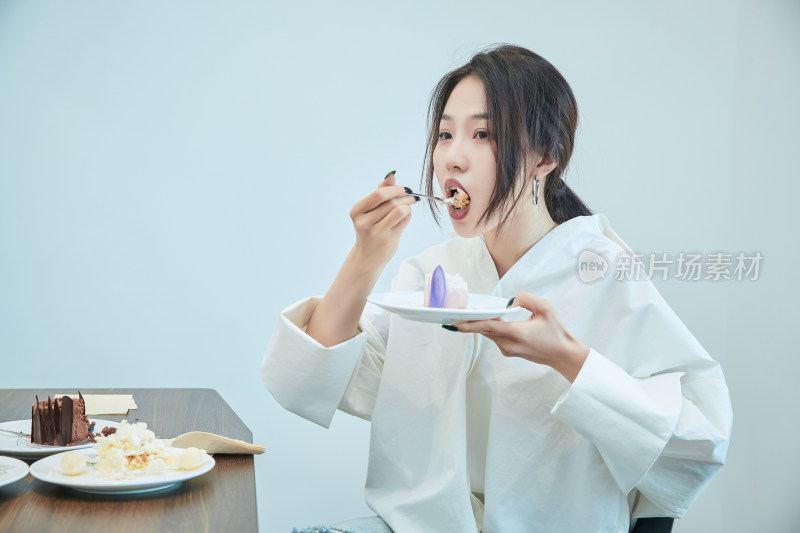 在烘焙店吃蛋糕喝饮料的可爱亚洲少女