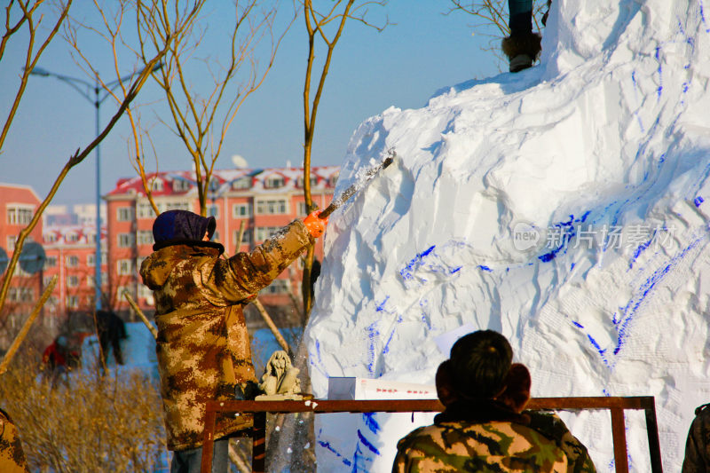 在哈尔滨人们户外合作制作大型雪雕