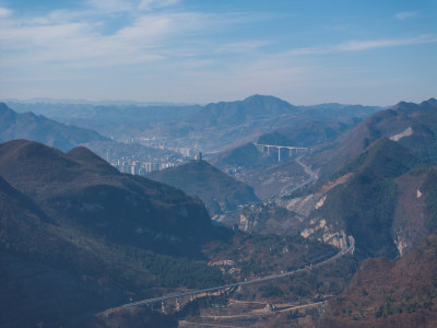 山间城镇全景，高架公路贯穿其中