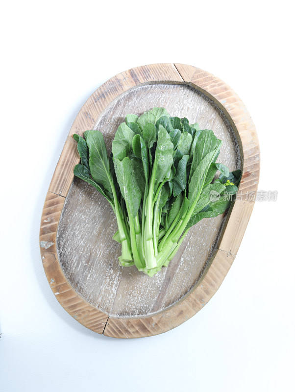 白色背景上，菜篮子装着的绿色蔬菜菜心青菜
