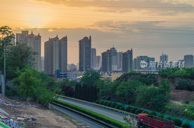 夕阳下城市高楼与高速公路景观