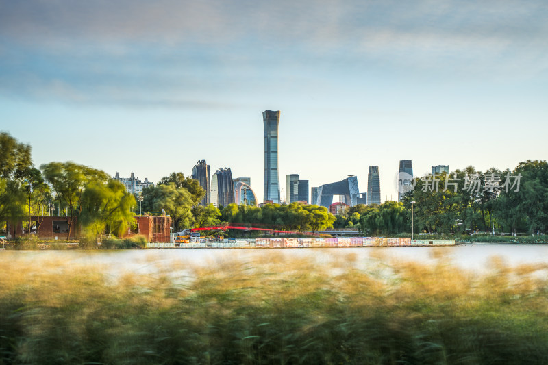 北京湖畔草地间的城市天际线