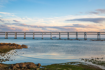 黄昏日落时的大连黑石礁公园海滩和跨海大桥