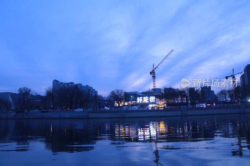 河畔傍晚城市建筑与施工景象