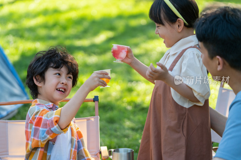 一家四口在露营地野餐开心干杯庆祝