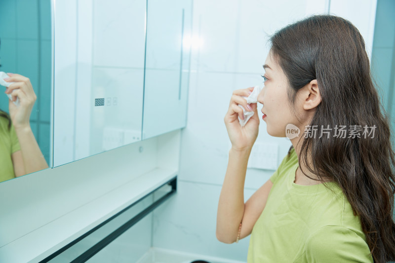 在卫生间对着镜子整理妆容的亚洲少女