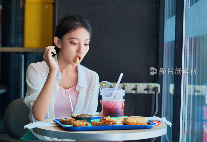 在商场快餐厅大吃特吃的中国可爱少女人像