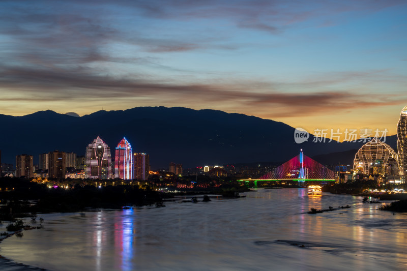 暮色下依山傍水的西双版纳多彩城市夜景