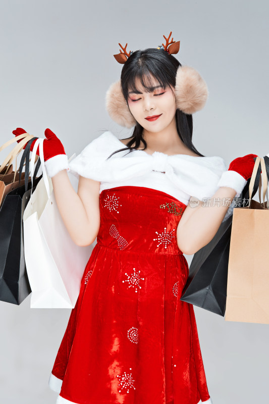 身穿圣诞服饰手提购物袋性感可爱的圣诞女郎