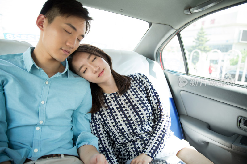 青年情侣坐在车里睡觉