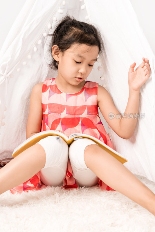 坐在白色帐篷内读书的女孩
