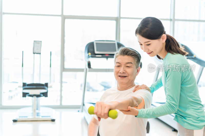 老年男子在私教的指导下健身