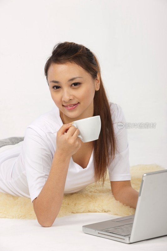 年轻女人喝咖啡使用笔记本电脑